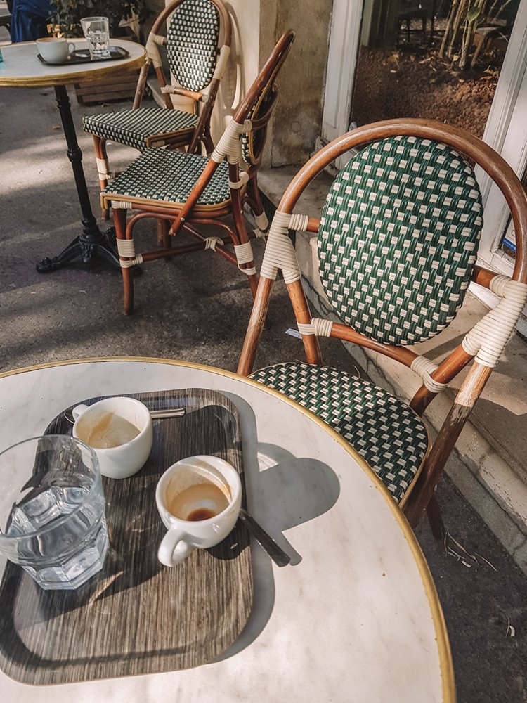 Mesa típica dos cafés de Paris, com xícaras de café vazias.