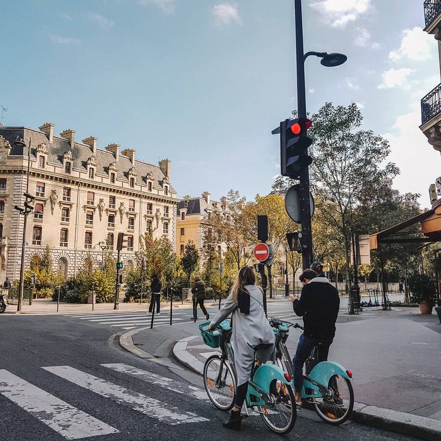Casal anda de bicicleta por Paris.